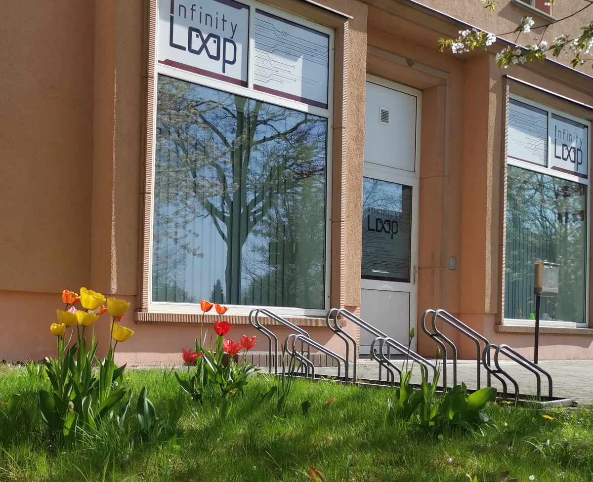 Firmensitz der InfinityLoop GmbH & Co. KG in der Ernst-Thälmann-Straße 117A, Senftenberg: Schaufenster mit InfinityLoop-Logo, Eingangstür und Fahrradständer