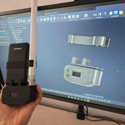 Hand hält einen 3D-gedruckten Gehäuseprototyp vor einem CAD-Modell am Bildschirm